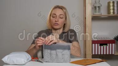 女博主坐在一张桌子旁，在网上<strong>商</strong>店里研究一次购买。